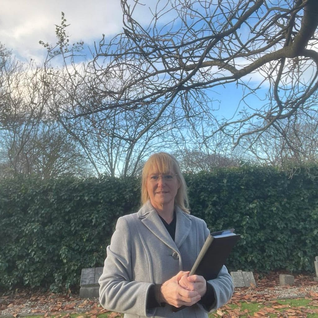 Fleur standing with her folder in a cemetery on a sunny winter's day