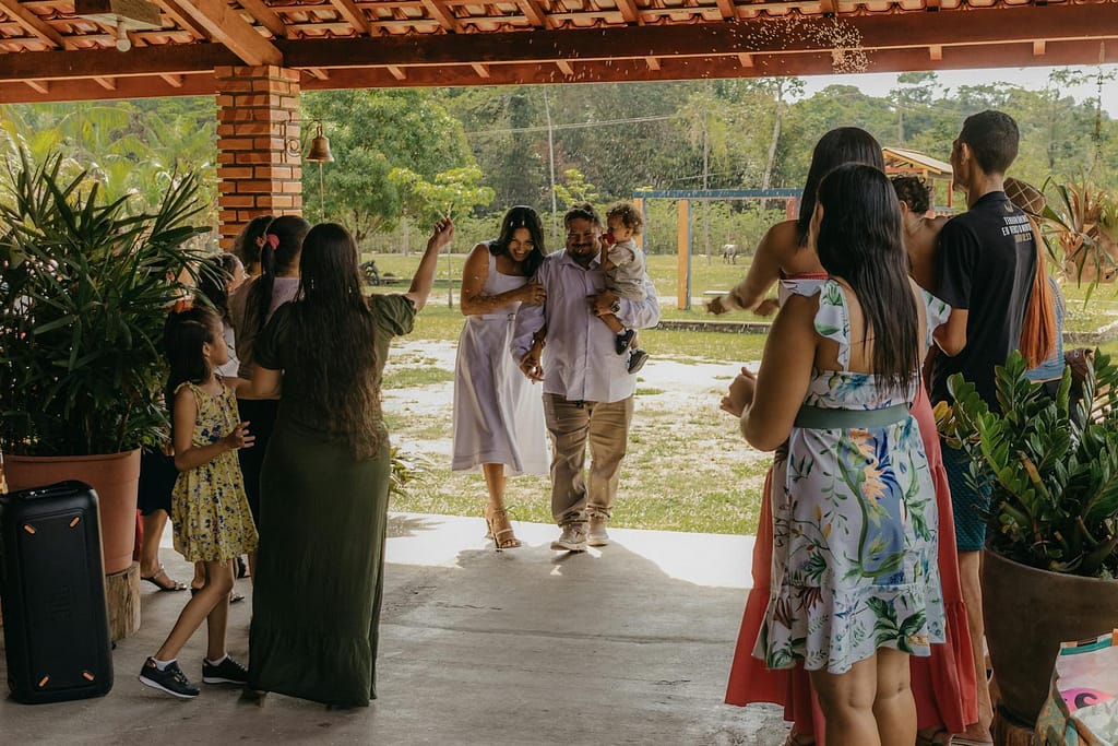 A couple joyfully celebrated outdoors with family and friends, surrounded by nature.