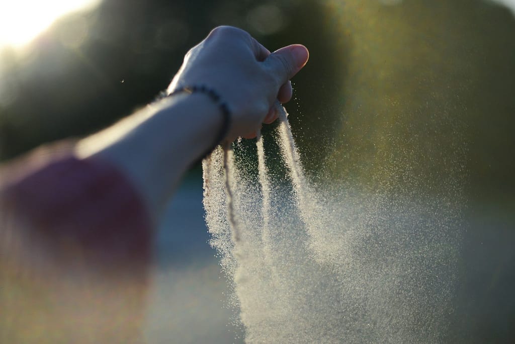 A person holding their hand out to scatter ashes
