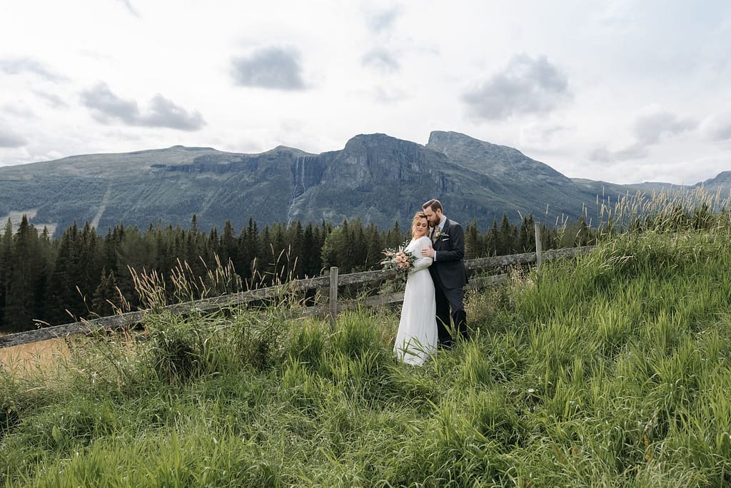 Bride and groom embrace in a beautiful mountainous landscape.
