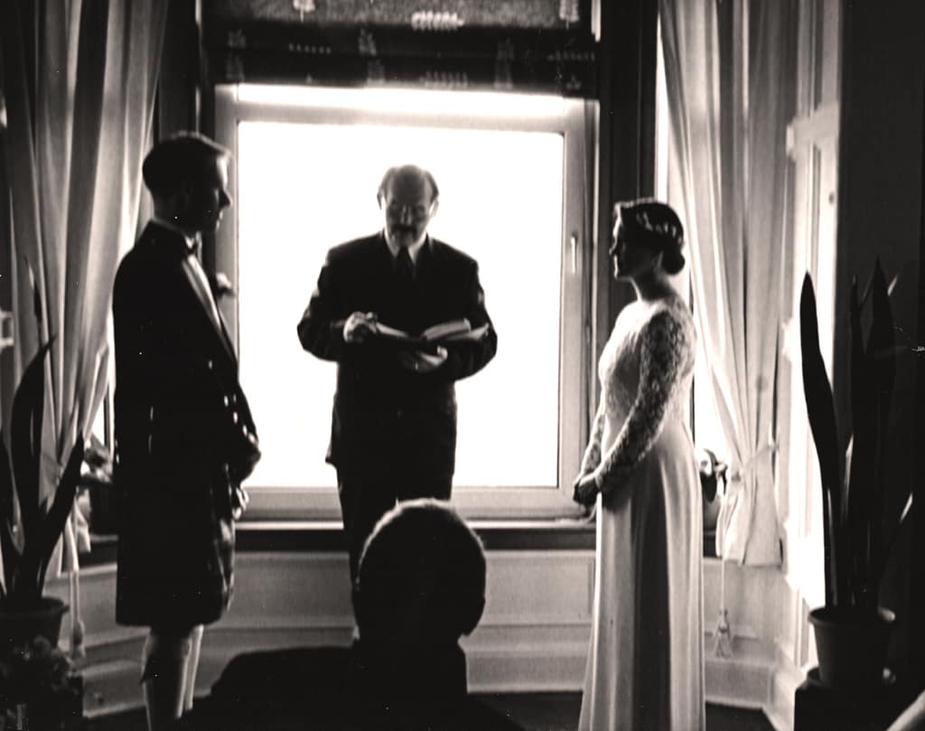 Fleur and husband and their celebrant in their lounge for their wedding ceremony.