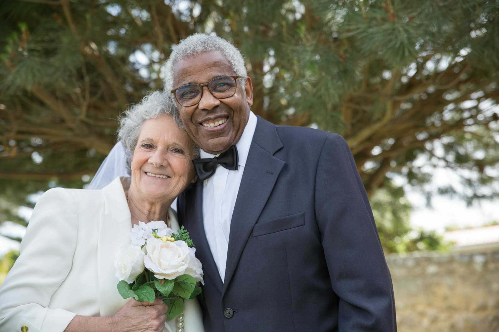 Senior couple posing outdoors in Portugal, celebrating their wedding day with smiles and joy.