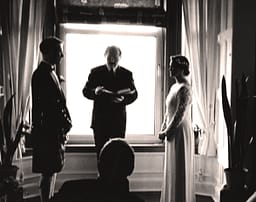 Fleur and husband and their celebrant in their lounge for their wedding ceremony.
