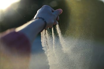 A person holding their hand out to scatter ashes